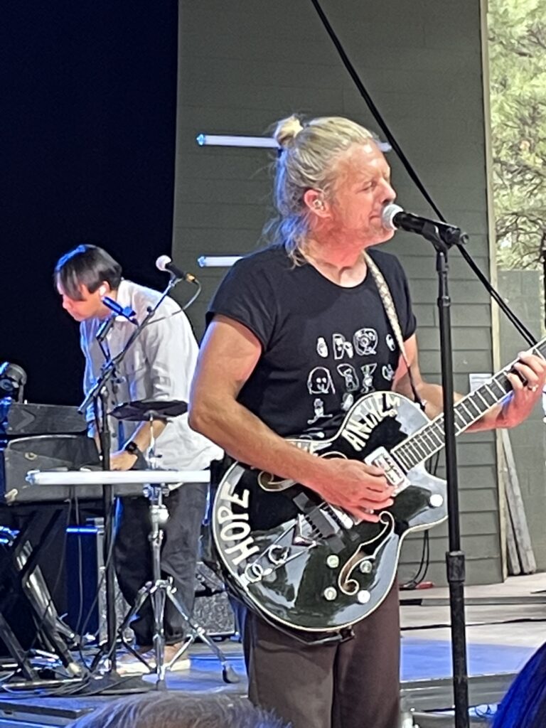 Lead vocalist singing while playing guitar